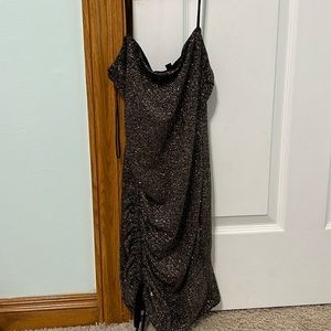 a black sparkling dress with a slit on the right leg and cute ties on the left